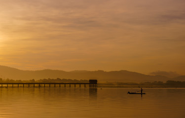 Fototapeta premium Men are fishing on a boat in a reservoir in the morning.