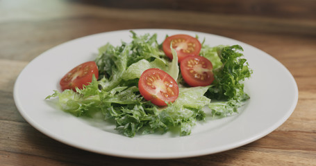 closeup adding tomatoes to caesar salad