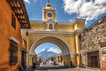 Antigua Guatemala, Arco de Santa Catalina and Volcano Agua - obrazy, fototapety, plakaty