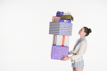 side view of woman holding pile of wrapped presents isolated on white