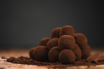 craft chocolate truffles on wooden board with cocoa powder