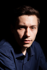 Fototapeta premium Portrait of young man in his 20s on black background in studio photo