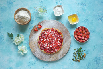Strawberry pie. Ingredients for baking a strawberry pie on a turquoise kitchen table.