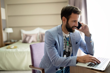 Businessman working on computer in hotel room