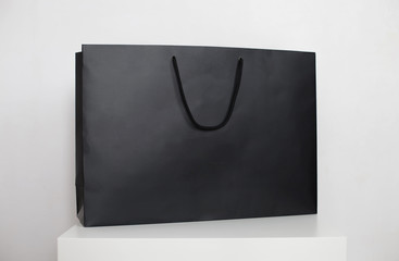 Black shopping bag with handles on a white background. Advertising and branding
