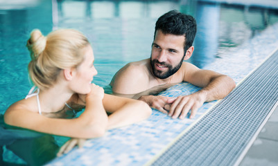 Fototapeta premium Happy attractive couple relaxing in swimming pool