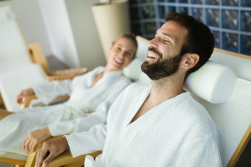Attractive happy couple relaxing in spa center