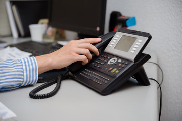 Closeup on busy office phone workplace, light table window. Modern administration control lcd display support solution response. Digital connection device communication landline equipment technology