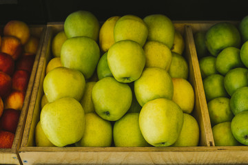 Beautiful, juicy and fresh apples lie on the shelf in the supermarket. Seasonal and exotic vegetables and fruits