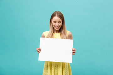 Beautiful woman holding a blank billboard isolated on blue background