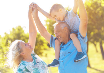 Grandparents with grandson enjoying time together in park.