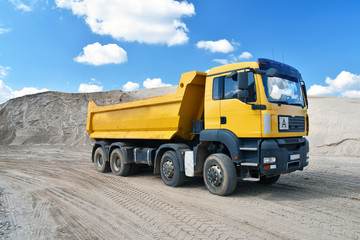 Fototapeta na wymiar LKW transportiert Sand/ Baustoffe in einem Kieswerk // Truck transports sand in a gravel pit - gravel mining in an open pit mine