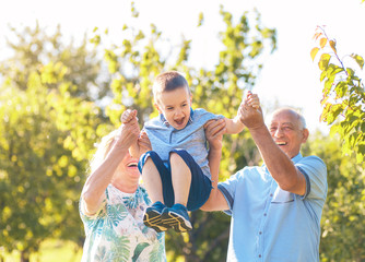 Grandparents with grandson enjoying time together in park.