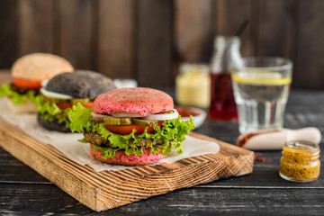 Tasty hamburger with meat and vegetables against a dark background. Fast food. It can be used as a background