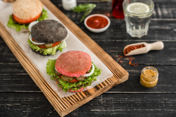 Tasty hamburger with meat and vegetables against a dark background. Fast food. It can be used as a background