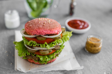Tasty hamburger with meat and vegetables against a dark background. Fast food. It can be used as a background