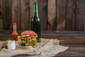 Tasty hamburger with meat and vegetables against a dark background. Fast food. It can be used as a background
