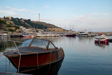 Sfondo con barca in porto e il Faro di Santa Maria di Leuca,Salento-Puglia