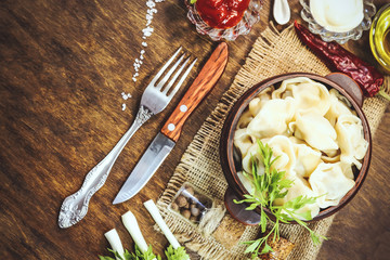 dumplings in earthenware. food ingredients. wooden background.