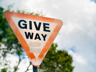 Give way sign on a suburban road under overcast skies in the Seychelles.