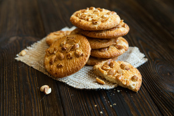 Crunchy cookies with peanuts on wooden table