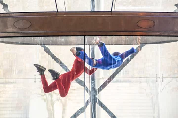 Tuinposter Skydivers in indoor wind tunnel, free fall simulator © Delphotostock