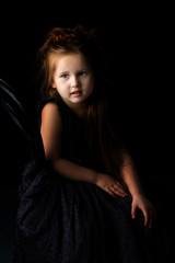 Naklejka premium Little girl on a black background