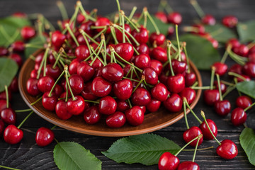 Tasty juicy sweet cherry on a wooden background. It can be used as a background