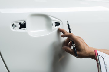 Auto body repair series: Inspector inspecting freshly repaint car