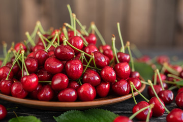 Tasty juicy sweet cherry on a wooden background. It can be used as a background