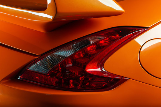 Fototapeta Car detailing series: Clean taillights of orange sports car