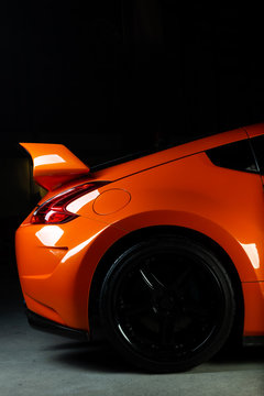 Fototapeta Car detailing series: Clean of rear orange sports car in the dark