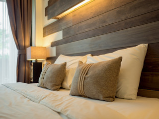 Empty double bed and lamp on side of bed in luxury and natural style bedroom is decorated with...
