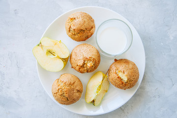 Gluten free almond flour muffins with apples in a bowl on a white stone background.