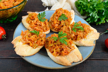 Squash caviar on a crispy baguette on a dark wooden table. Sandwiches with stewed vegetables. Vegan appetizer.