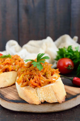 Squash caviar on a crispy baguette on a dark wooden table. Sandwiches with stewed vegetables. Vegan appetizer.
