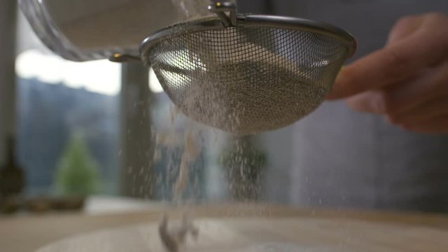 Woman sifting flour through a sieve