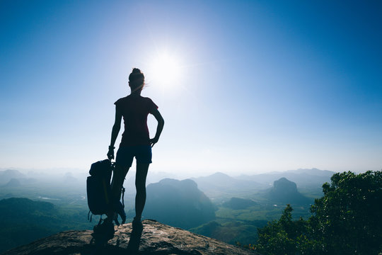 Successful woman hiker in the sunrise mountain top
