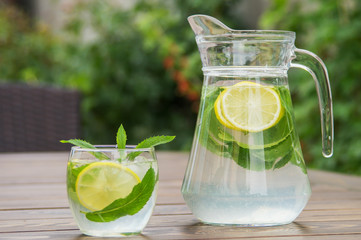 Fresh homemade lemonade with ice and mint on the table.