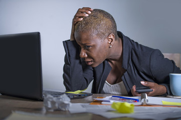 young desperate and stressed african american business woman working at laptop computer desk at office suffering stress feeling sad depressed