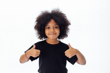 Adorable and cheerful African American kid with afro hairstyle giving thumbs up isolated over white background