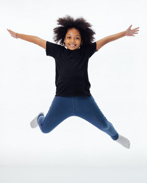 Happy And Fun African American Black Kid Jumping With Hands Raised Isolated Over White Background