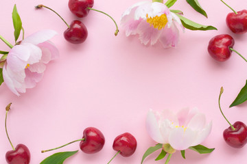 Spring or summer mood concept. Flatlay of cerry and peonies over pastel pink background. Top view...