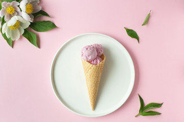 Spring or summer mood concept. Flat-lay of waffle sweet cone with berryy over pastel light pink background, top view.