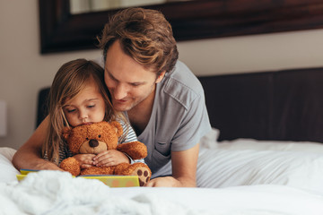 Father and daughter reading a story book © Jacob Lund