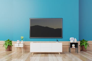 TV on cabinet in modern living room with table,flower and plant on blue wall background,3d rendering