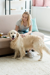 teen student girl petting her adorable golden retriever at home