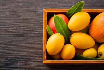 Fresh and beautiful mango fruit set in a wooden box on a dark wooden background, copy space(text space), blank for text
