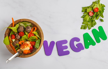 Vegetarian buddha bowl with vegetables, hummus and bean meatballs on white background. Healthy vegan food concept.