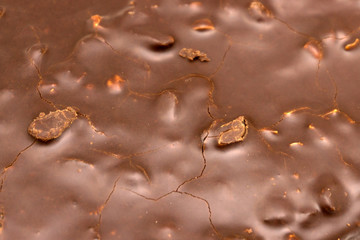 Macro close up of fine chocolate chopped by hand, sliced off the block with a knife.